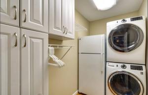 a kitchen with a washer and dryer next to a refrigerator at Backwater Cove 4 Bed25 Bathdockdeck-sleeps 12 in Osage Beach