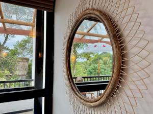 Swastha Ayurveda Villa في هيكادوا: مرآة معلقة على جدار مع نافذة