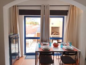 a dining room with a table and chairs with a view at Casa Susana in Atouguia da Baleia +16 photos