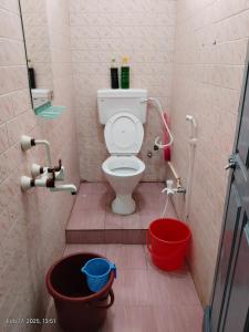 a bathroom with a toilet and a red bucket at Villa VOC in Puducherry +13 photos
