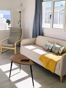 a living room with a couch and a chair at Casa Lila, paz junto al mar in Guatiza