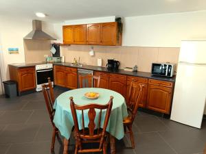a kitchen with a table and chairs and a refrigerator at Hoeve Hofgaarde in Heers