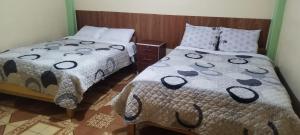 a bedroom with two beds and a bedspread with at Hospedaje Paris in Puno