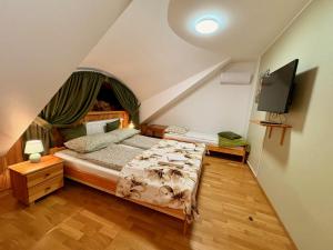 a bedroom with a bed and a flat screen tv at Dębowa Dziupla in Białowieża