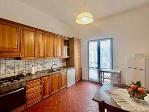 a kitchen with wooden cabinets and a table with a bowl of fruit at Villino Rita in Portoferraio