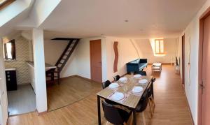 a dining room and living room with a table and a staircase at Cosy 4 - Montbéliard centre 80m2 in Montbéliard