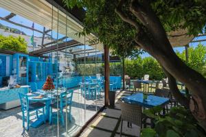 a restaurant with blue tables and chairs and a tree at Capri Dreaming in Anacapri