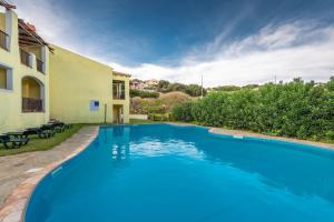 a large blue swimming pool next to a building at Charming Sea Villa shared pool Sleeps 6 V6IN in Cuile Pazzoni