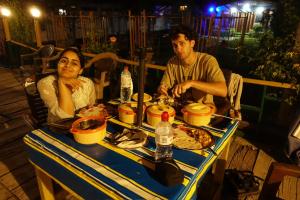 a man and a woman sitting at a table with food at Hotel sea face in Srinagar