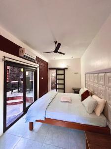 a bedroom with a large bed with a ceiling fan at Sabera Heritage Homestay in Sakleshpur +13 photos