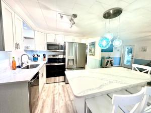 a kitchen with white cabinets and a sink and a counter at Cabin by the Sea - Waterfront Direct Gulf Access- Pontoon Boat Rental On Site or Bring Your Boat- Paddlecraft included in Hernando Beach