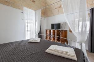 a bedroom with a bed with two towels on it at Suite Princess Sophie in Ostuni