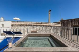 a pool on a balcony with a chair and an umbrella at Suite Princess Sophie in Ostuni
