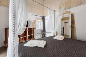 a bedroom with a bed with two towels on it at Suite Princess Sophie in Ostuni +22 photos