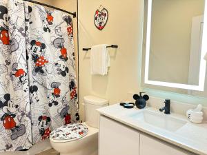 Un baño con inodoro y cortina de ducha. en TR1386PNW - 9 guests - pool home close to Disney, en Clermont 15 fotos más