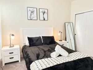 Un dormitorio con una cama con dos mesitas de noche y dos lámparas. en TR1386PNW - 9 guests - pool home close to Disney, en Clermont