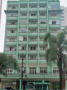 um edifício alto com palmeiras na frente em Apezito em Santos mais 4 fotografias