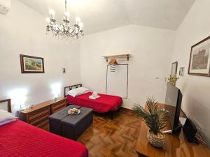 a living room with two beds and a chandelier at Ellera Suite con Parcheggio Privato - Albisola Superiore in Stella