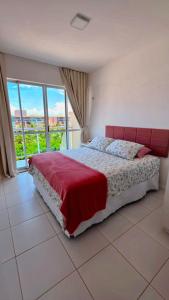 a bedroom with a bed with a red headboard at Cobertura Duplex Porto das Dunas in Aquiraz