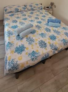 a bed with a blue and white comforter at Stella Marys Sud in Olbia +25 photos