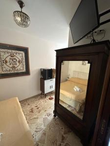 a bedroom with a mirror in the corner of a room at TINY HOUSE in the HEART of TAORMINA in Taormina