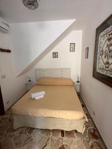 a bedroom with a bed in a white room at TINY HOUSE in the HEART of TAORMINA in Taormina