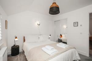 a white bedroom with two towels on a bed at 27 Strathtay Lodges in Aberfeldy
