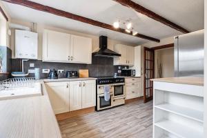 a kitchen with white cabinets and stainless steel appliances at Keith - Spacious 4 bed house in Keith