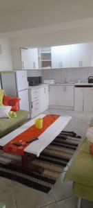 a kitchen with white cabinets and a table in it at Macaw Villa in Mossel Bay