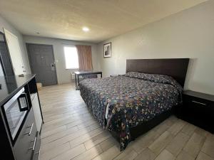 ein Schlafzimmer mit einem Bett und einem Tisch und einem Fenster in der Unterkunft Budget Inn Motel in San Antonio + 5 Fotos