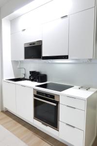 a white kitchen with a stove and a microwave at Henniina V Karjasilta - Free parking in Oulu