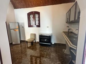 a kitchen with a sink and a refrigerator and a table at ZAIN PALACe in Jazīrat al ‘Awwāmīyah