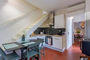 Una cocina y un comedor con una mesa y una escalera. en Le 9 Victor Hugo Vue sur les Toits, Loft Triplex avec terrasse, intra muros, en Saint-Rémy-de-Provence 41 fotos más