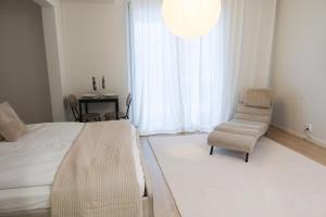 a bedroom with a bed and a chair and a window at Henniina V Karjasilta in Oulu