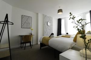 ein Schlafzimmer mit einem Bett und einem Schreibtisch in einem Zimmer in der Unterkunft - WINTER SALE - Entire 2-Bedroom Apartment in the bustling City Centre WIFI TRAIN & BUS STATION in Colchester