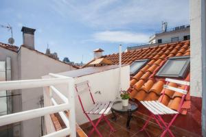 balkon z 2 krzesłami i stołem na dachu w obiekcie Fuencarral Apartments w Madrycie