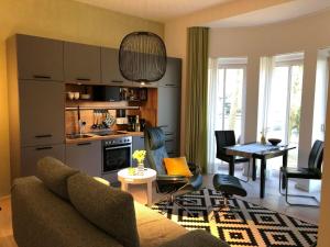 a living room with a couch and a dining room at Ferienwohnung Tannen Suite in Waren