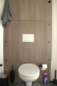 a white toilet in a bathroom with wooden walls at The waterfront & birds nest in Evergem