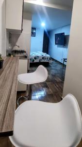 a kitchen with two white chairs in a room at El buen descanso in Fusagasuga