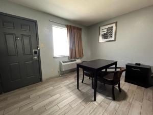 Zimmer mit einem Tisch, einer Tür und einem Fenster in der Unterkunft Budget Inn Motel in San Antonio