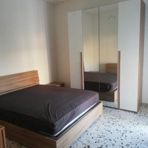a bedroom with a bed and a mirror at Donato C alloggio estivo in Scauri