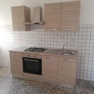 a kitchen with a stove and a sink at Donato C alloggio estivo in Scauri