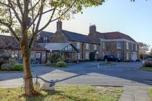 a large brick building with a tree in front of it at Knights Hill Hotel & Spa in Kings Lynn