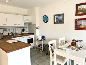 a kitchen with white cabinets and a table and a counter at Achtern Diek Haus 15d Wohnung 3 in Zingst