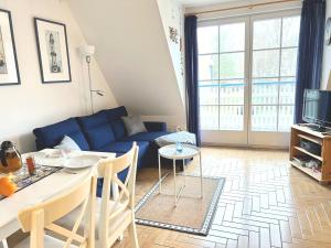 a living room with a blue couch and a table at Achtern Diek Haus 15d Wohnung 6 in Zingst