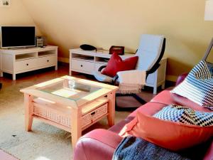 a living room with a couch and a table and a tv at Straminke 4b Wohnung Dünentraum in Groß Kirr