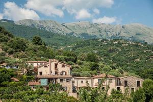 a group of buildings in front of a mountain at Azienda Agrituristica Bergi in Castelbuono