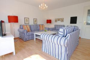 a living room with two couches and a table at Straminke 14 Haus Strandidylle in Zingst