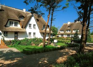 a large white house with a thatched roof at Achtern Diek Haus 12c Wohnung 4 in Müggenburg +1 photo