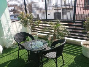 Un patio con dos sillas y una mesa en un balcón. en Cozy nook stay - Nearest stay from ram mandir 1 km, en Ayodhya